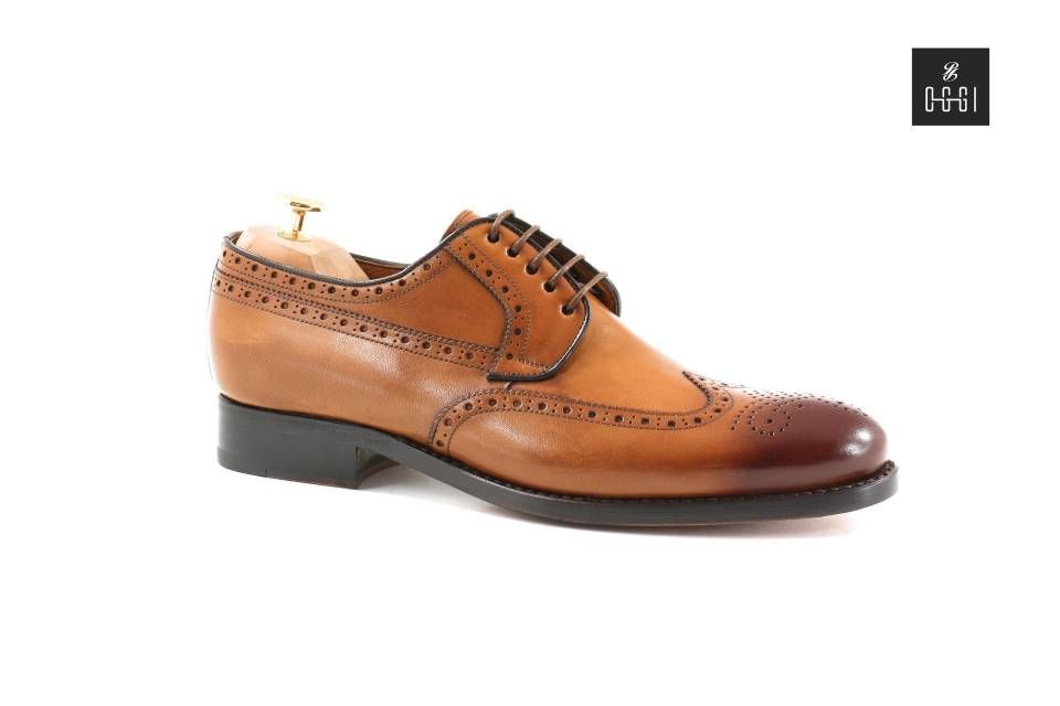 Une paire de chaussures marron avec une semelle noire sur fond blanc.