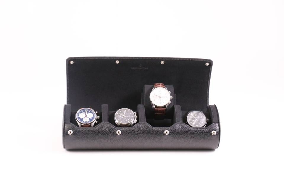 Un boîtier de montre en cuir noir avec quatre montres à l'intérieur.