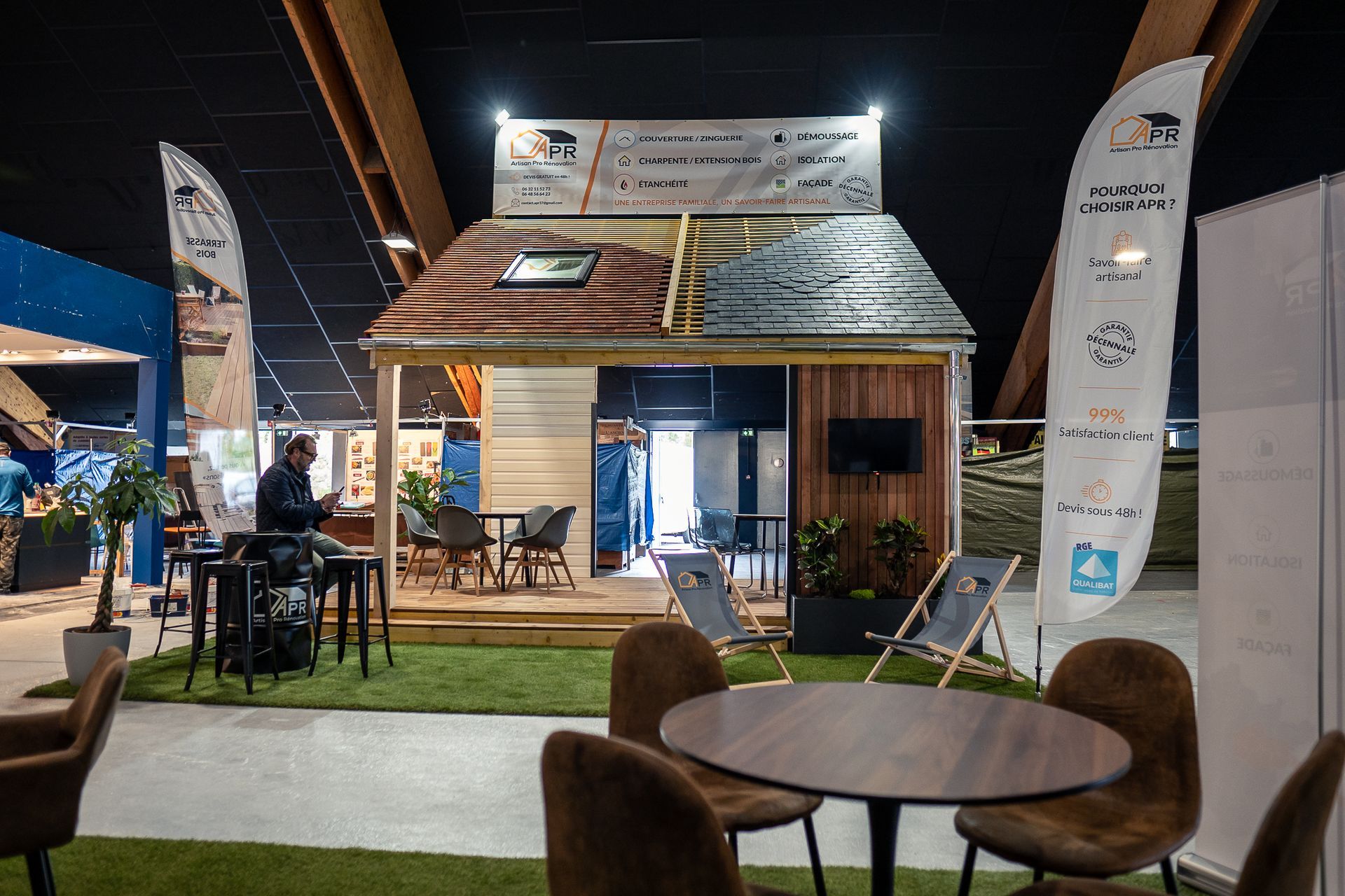 Stand avec une maison à ossature en bois montrant la toiture et le revêtement