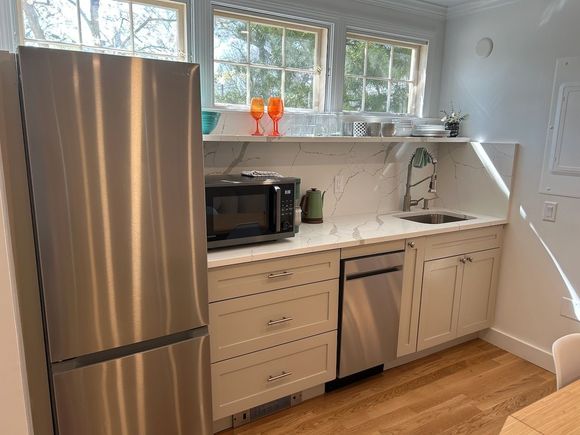 A kitchen with stainless steel appliances and white cabinets.