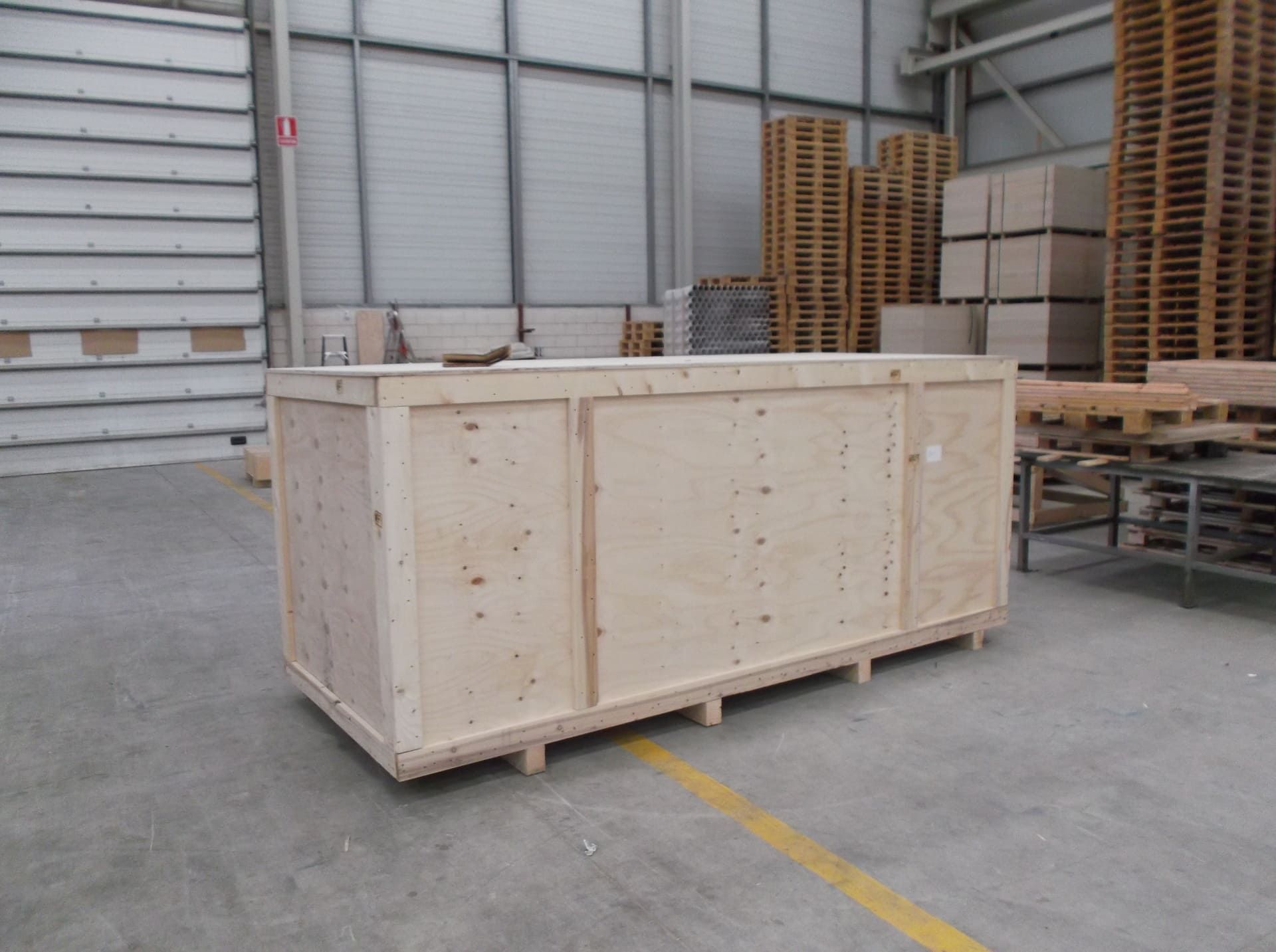 Una gran caja de madera se encuentra en un almacén.