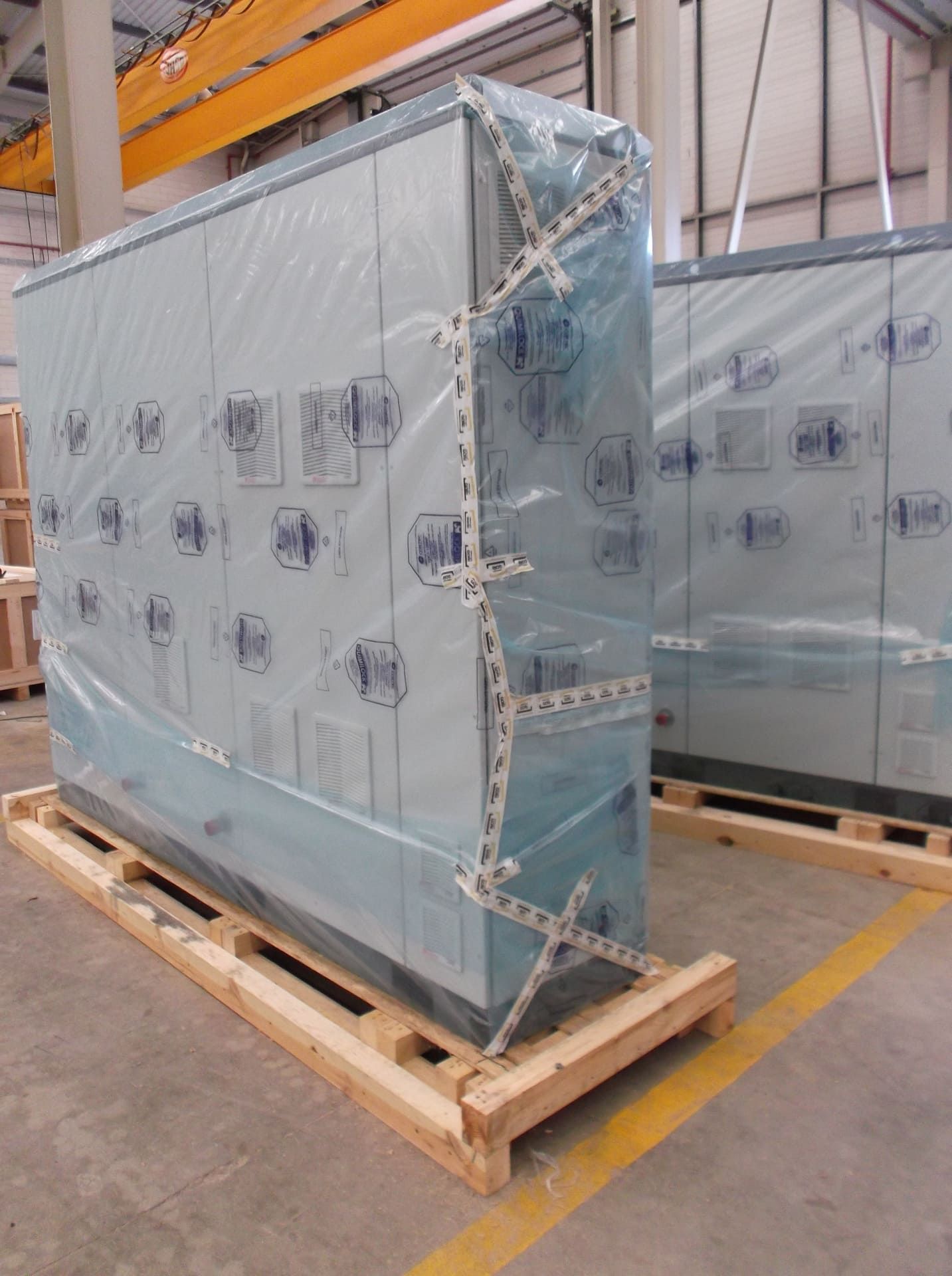 Una caja grande envuelta en plástico se encuentra sobre un palé de madera.