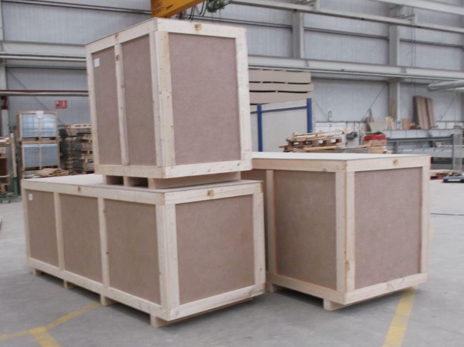 Tres cajas de madera están apiladas una encima de otra en un almacén.