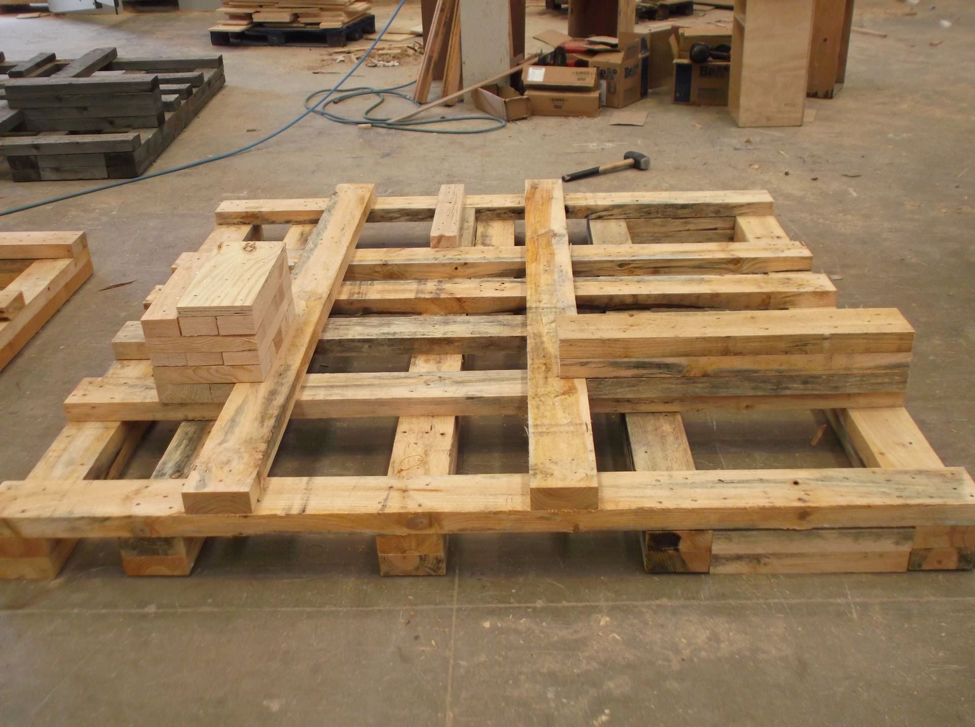 Una paleta de madera está colocada sobre un piso de concreto.