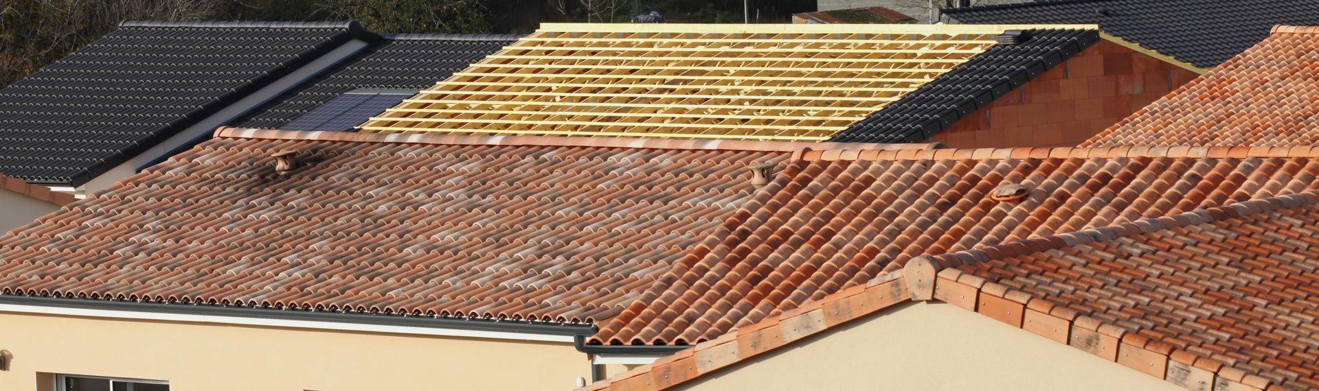 Toits de plusieurs bâtiments aux textures et couleurs variées.