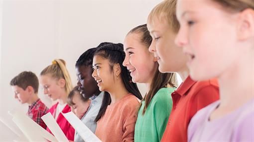 Eine Gruppe junger Leute singt gemeinsam in einem Chor.
