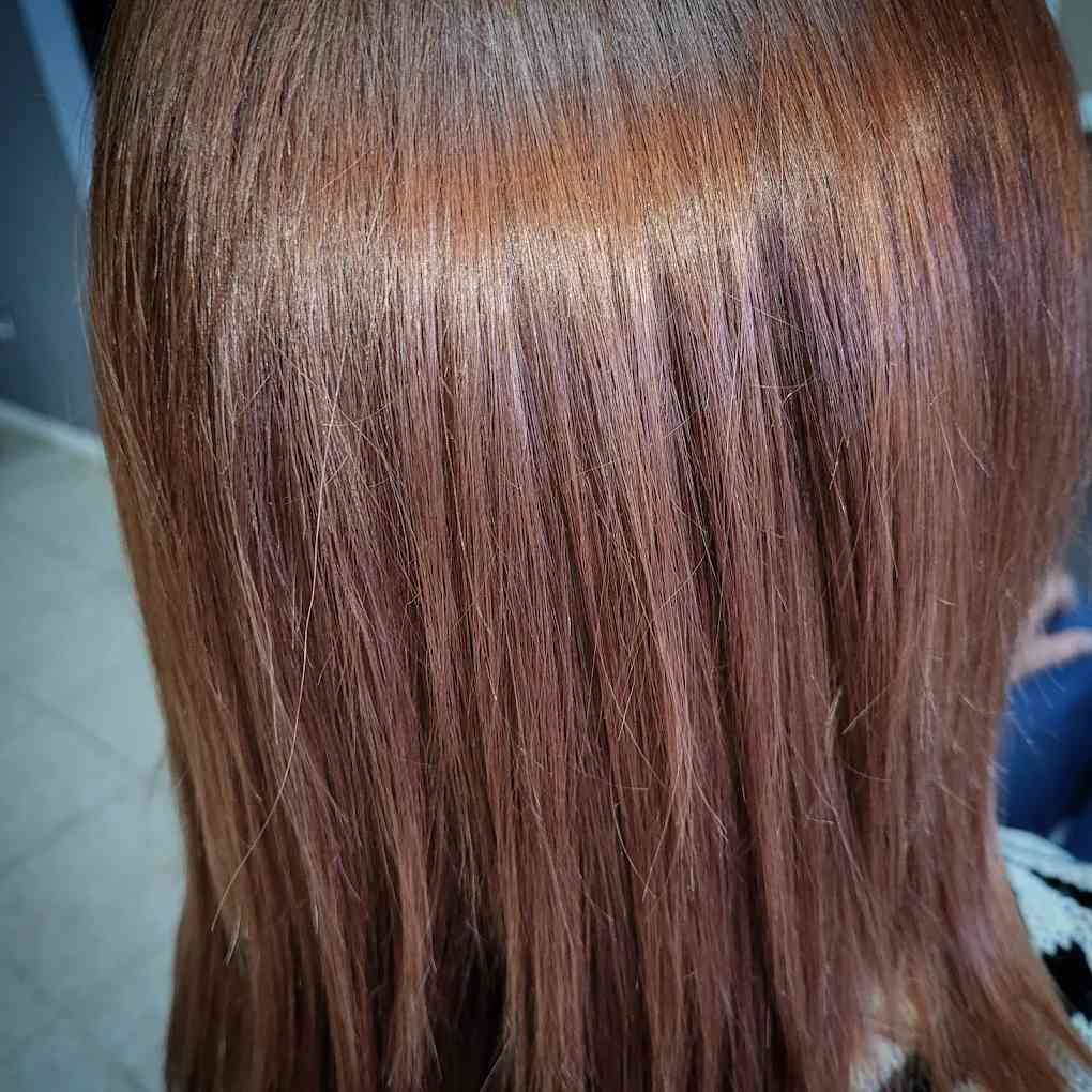 Primer plano de un cabello liso de color marrón rojizo con un aspecto brillante y saludable.