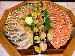 Auf einem Tisch steht ein Holztablett mit verschiedenen Speisen.