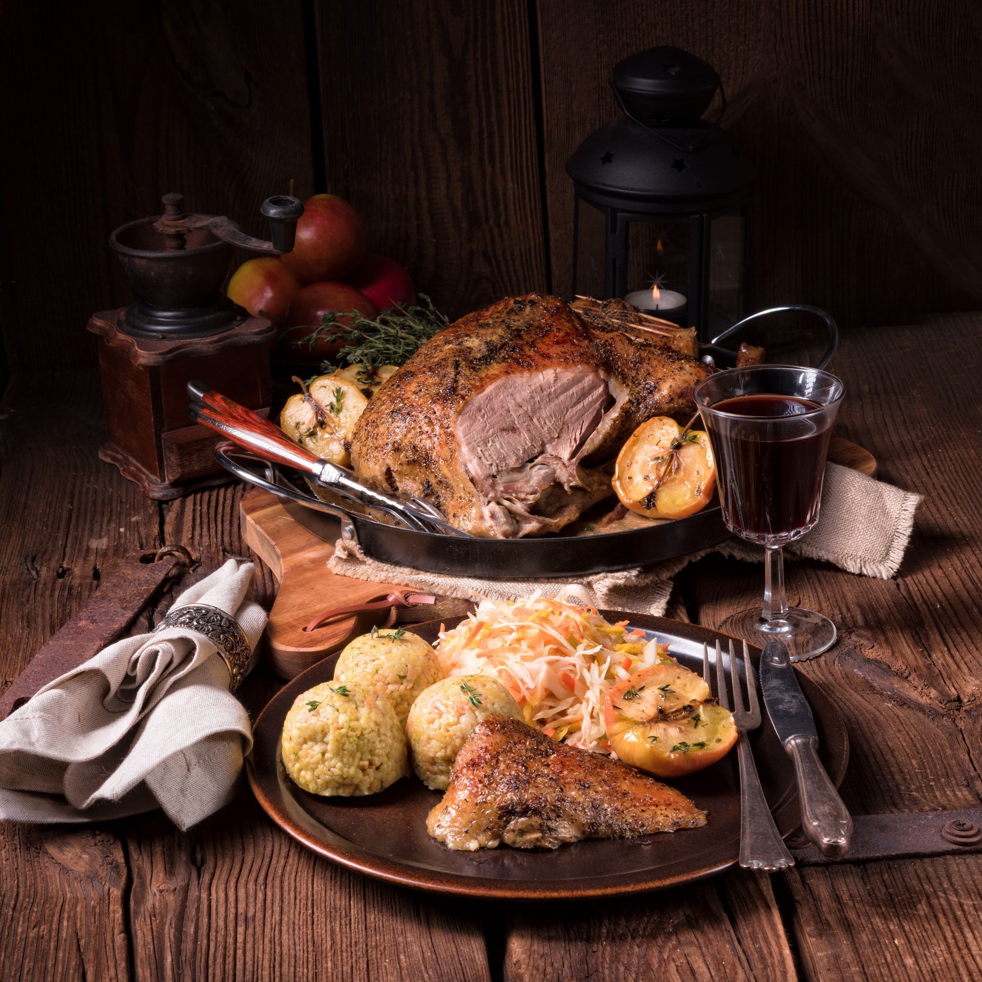 Ein Holztisch mit einem Teller Essen und einem Glas Wein.