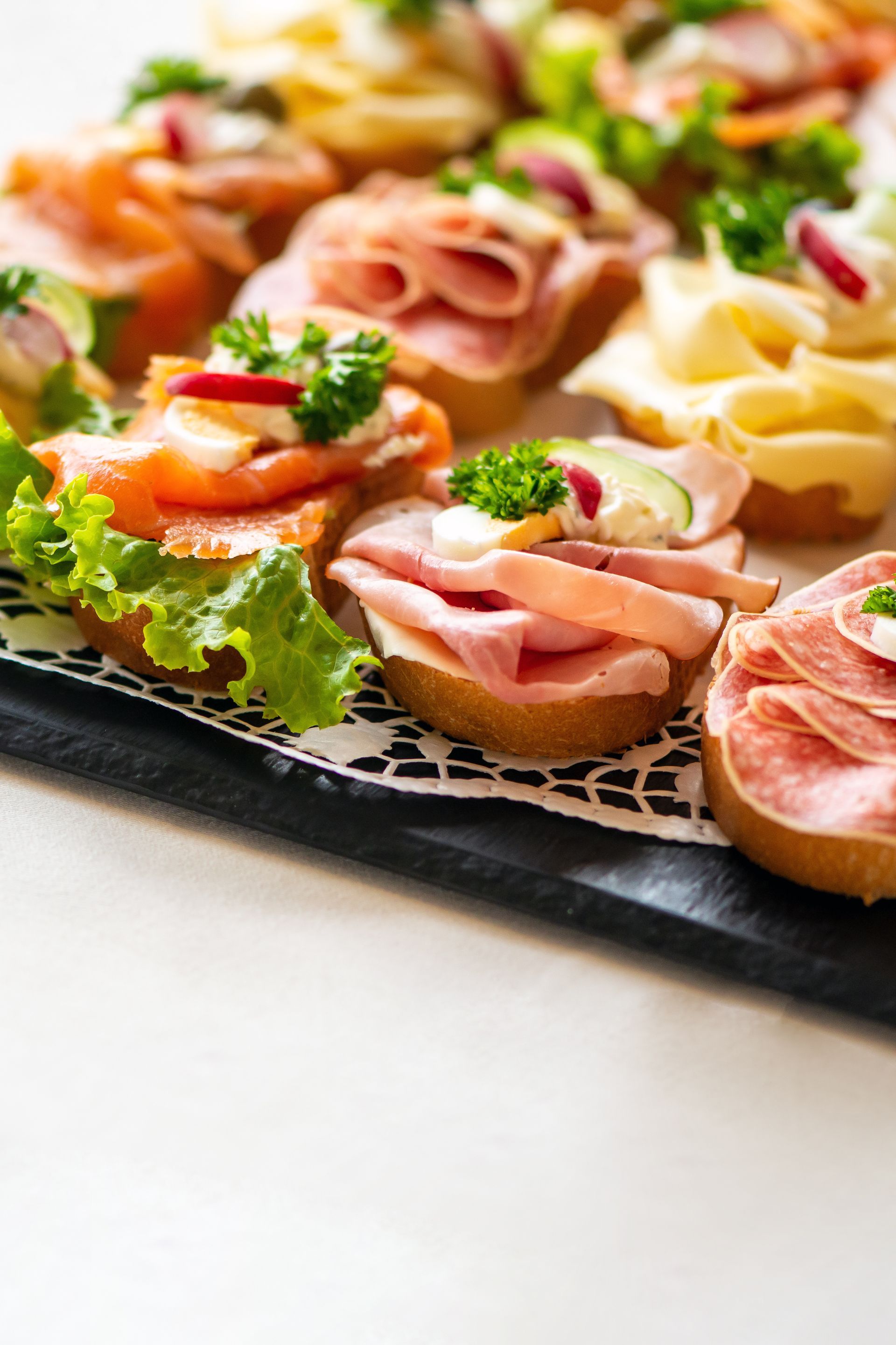 Eine Nahaufnahme eines Tabletts mit Sandwiches auf einem Tisch.