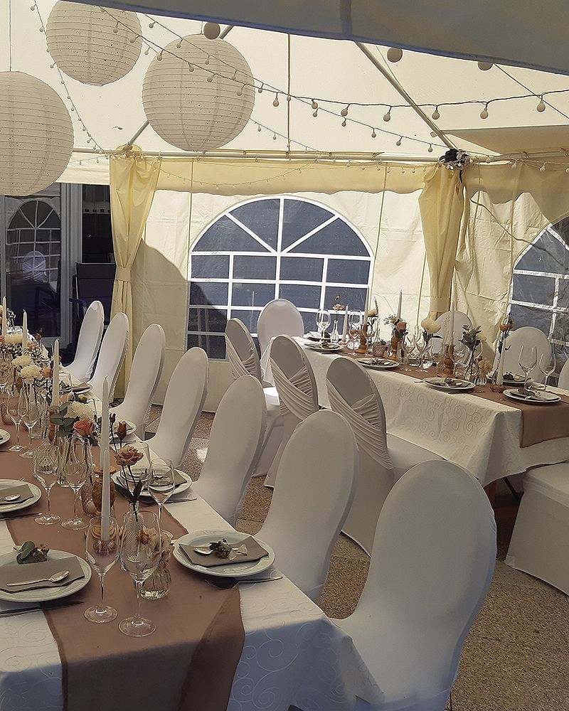 Ein Zelt mit Tischen und Stühlen für einen Hochzeitsempfang