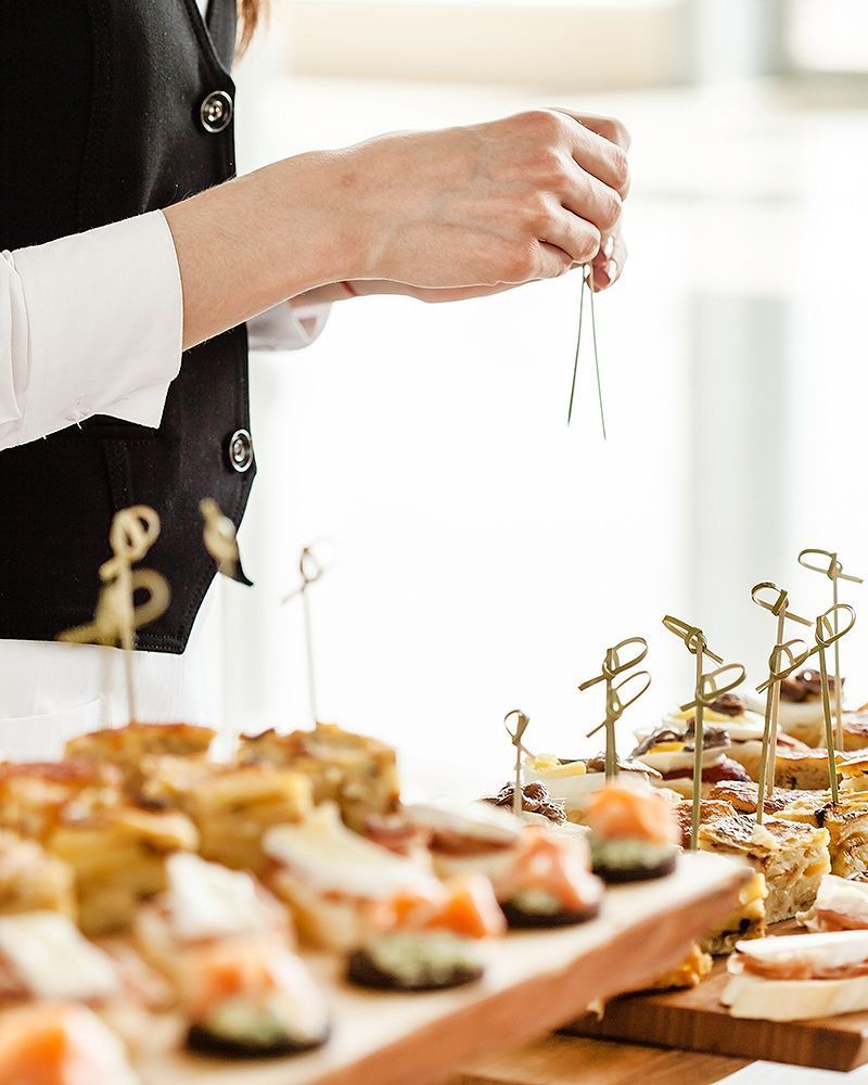 Eine Frau bereitet Essen auf einem hölzernen Schneidebrett zu.