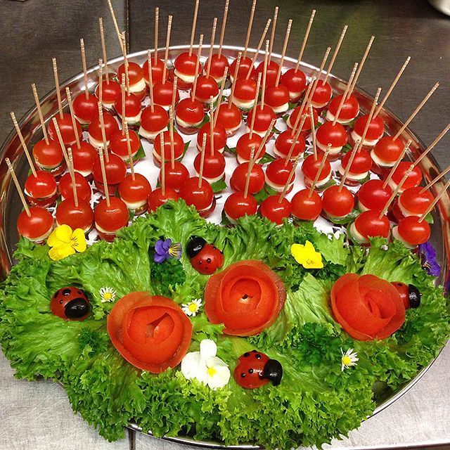 Ein Tablett mit Tomaten und Salat mit Marienkäfern darauf