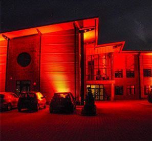 Ein großes Gebäude ist nachts mit roten Lichtern beleuchtet