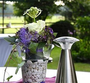 Auf einem Tisch steht eine Vase voller Steine ​​und Blumen.