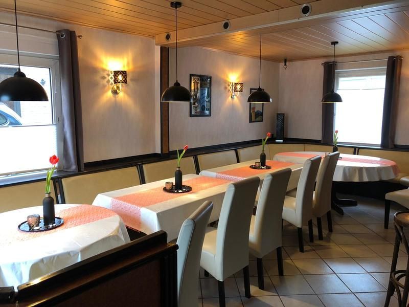 Ein Esszimmer mit Tischen und Stühlen und einem Fenster