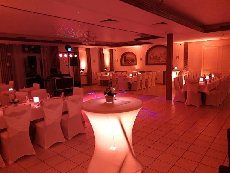 Ein großer Raum mit Tischen und Stühlen für eine Party
