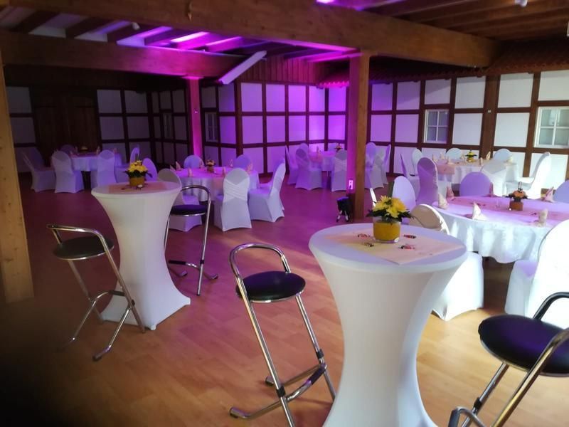 Ein großer Raum mit Tischen und Stühlen für eine Party