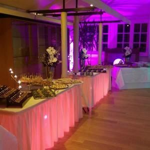 Ein großer Raum mit vielen Tischen und violetten Lichtern.