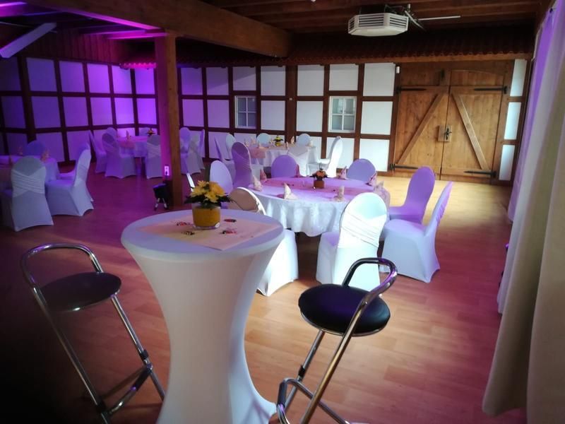 Ein Raum mit Tischen und Stühlen für einen Hochzeitsempfang
