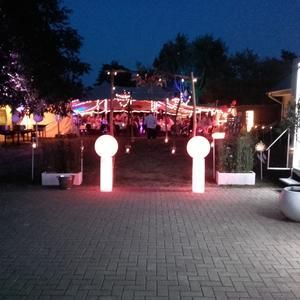 Eine Gruppe von Menschen versammelt sich nachts unter einem Zelt