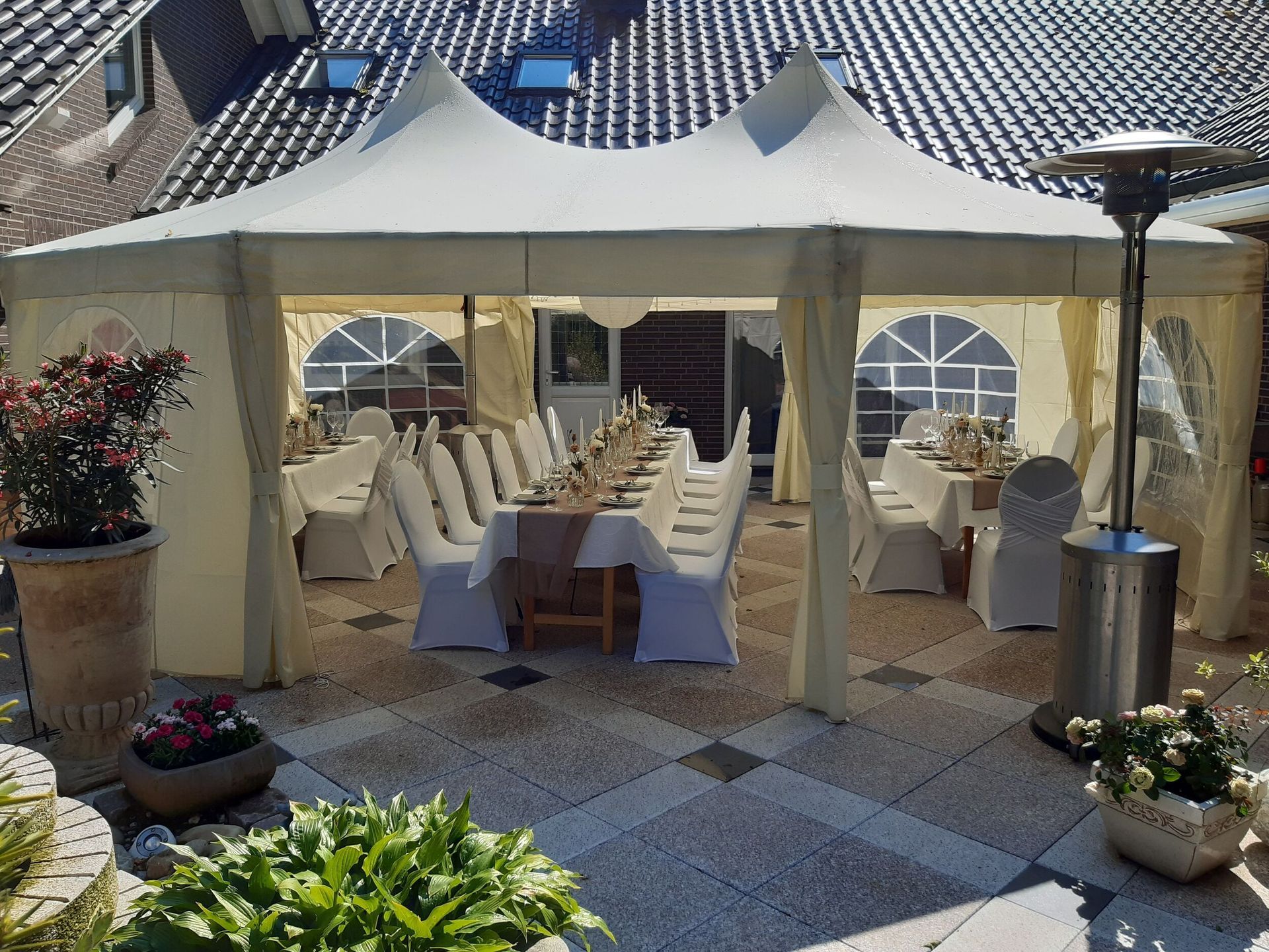 Ein großes weißes Zelt mit Tischen und Stühlen darin