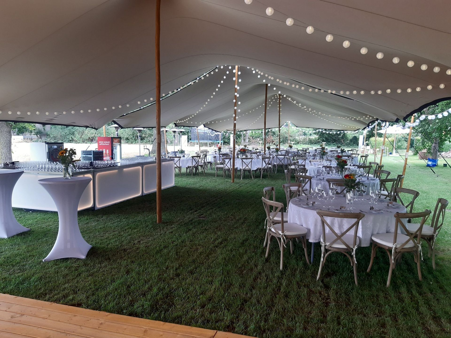 Ein großes Zelt mit Tischen und Stühlen darunter.