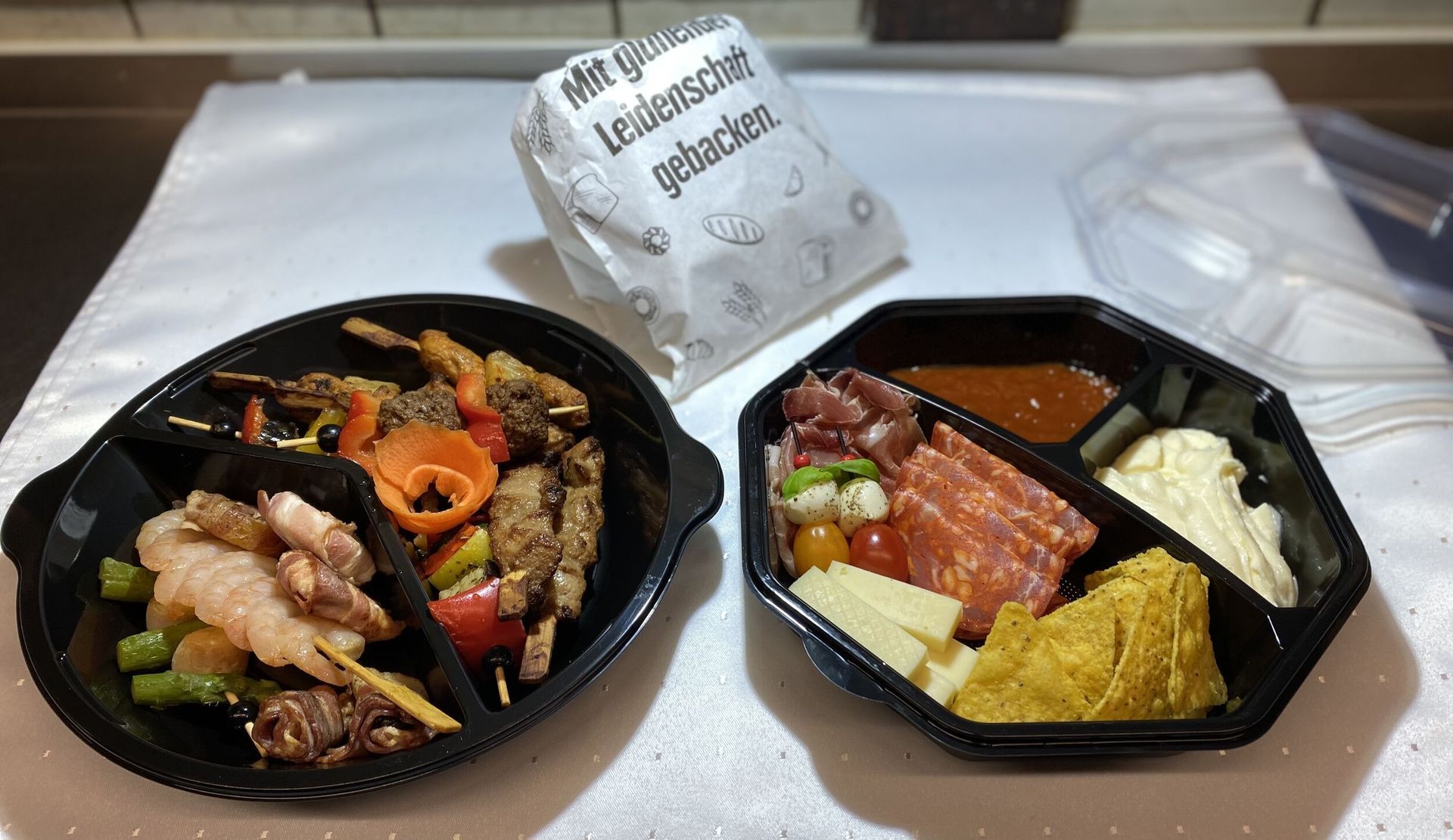 Auf einem Tisch stehen zwei Behälter mit Essen.