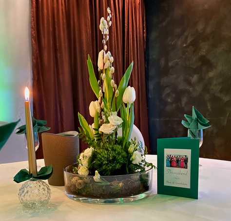 Ein Tisch mit einer Vase mit Blumen und Kerzen darauf