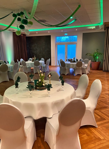 Ein großer Raum mit Tischen und Stühlen, die für eine Party aufgestellt sind.