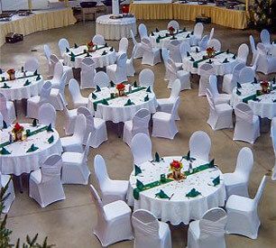 Ein großer Raum voller Tische und Stühle, die für einen Hochzeitsempfang aufgestellt sind.