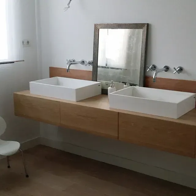Un baño con dos lavabos y un espejo.