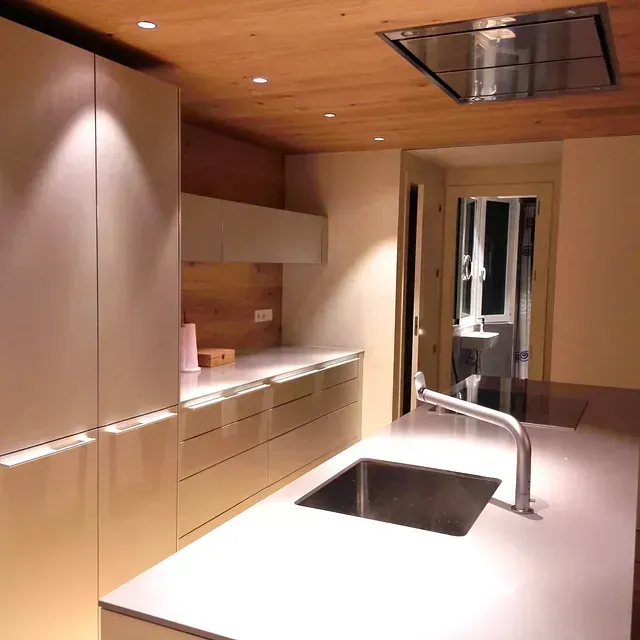 Una cocina con gabinetes blancos y un fregadero de acero inoxidable.