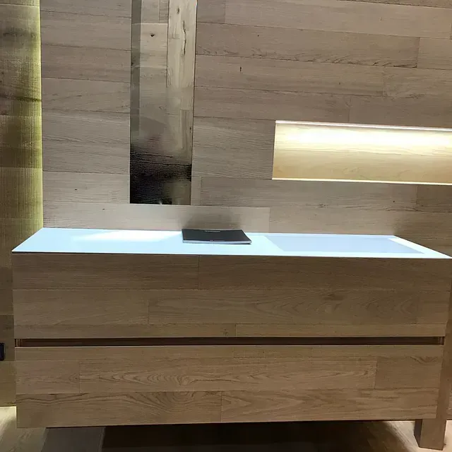 Un armario de madera con un lavabo blanco encima.