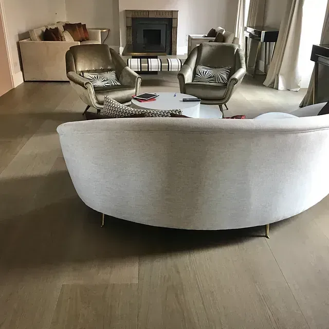 Una sala de estar con un sofá redondo y sillas.