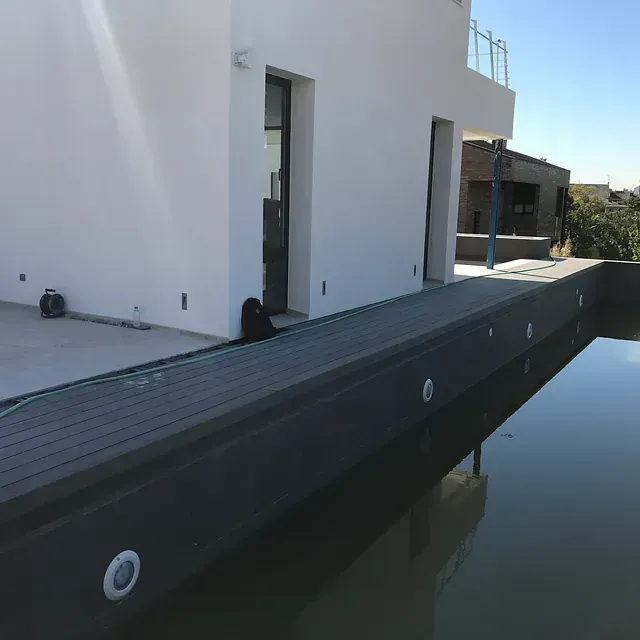 Un edificio blanco con una piscina enfrente.