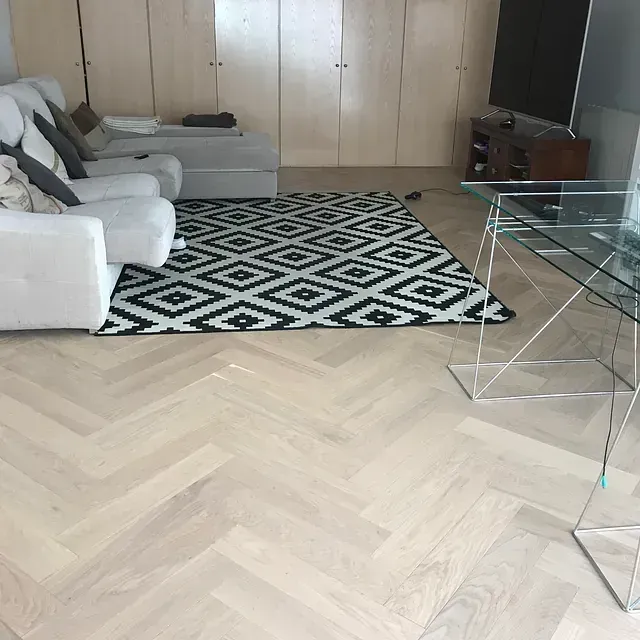 Una sala de estar con un sofá y sillas y una alfombra.