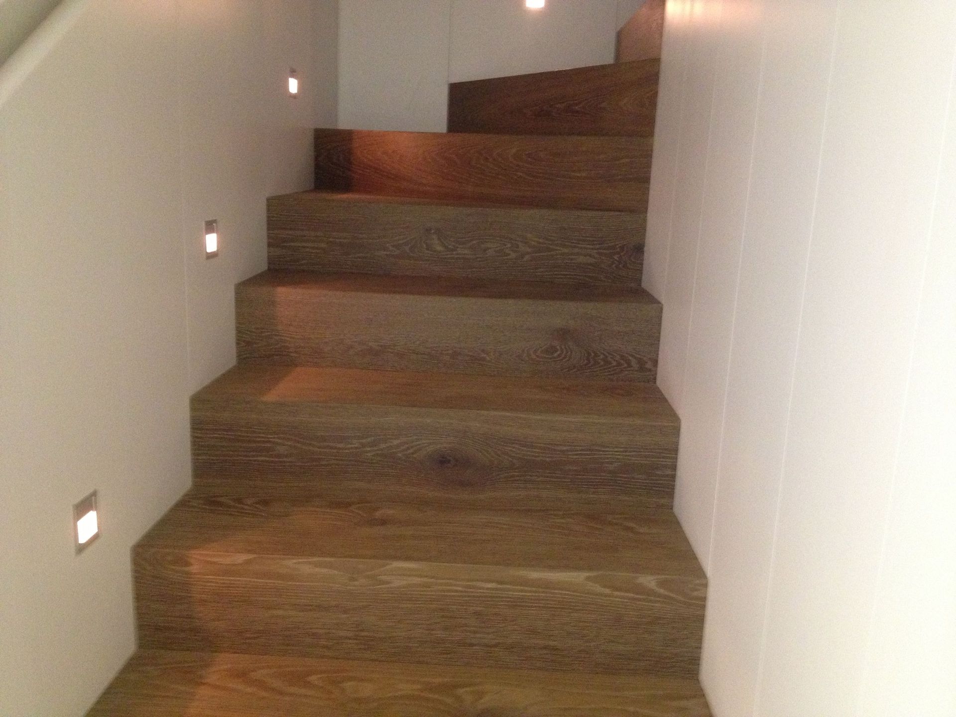 Un conjunto de escaleras de madera que conducen a una pared blanca.