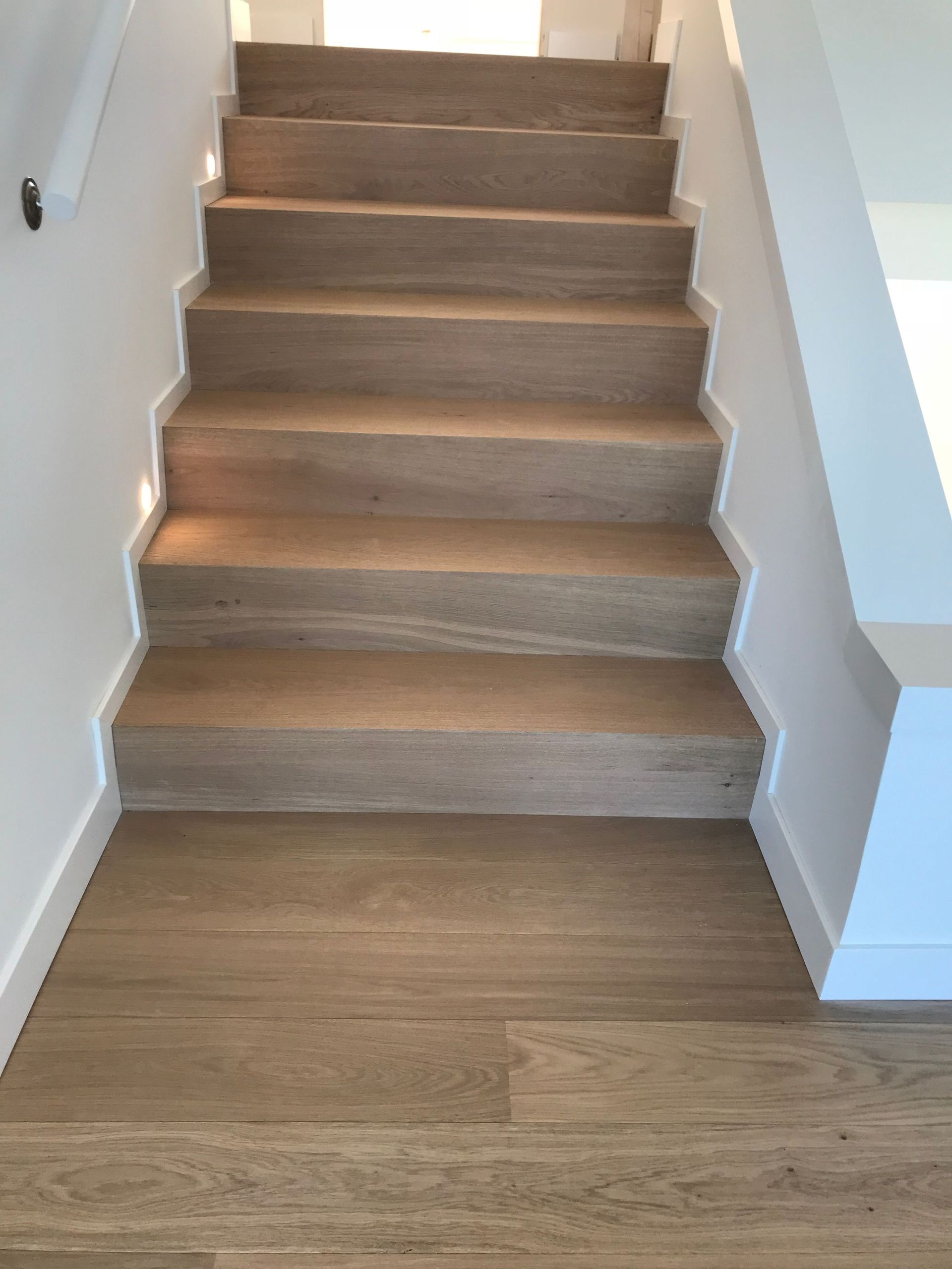 Una escalera de madera con piso de madera en una casa.