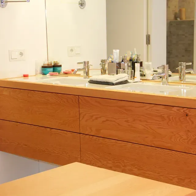 Un baño con dos lavabos y un espejo grande.