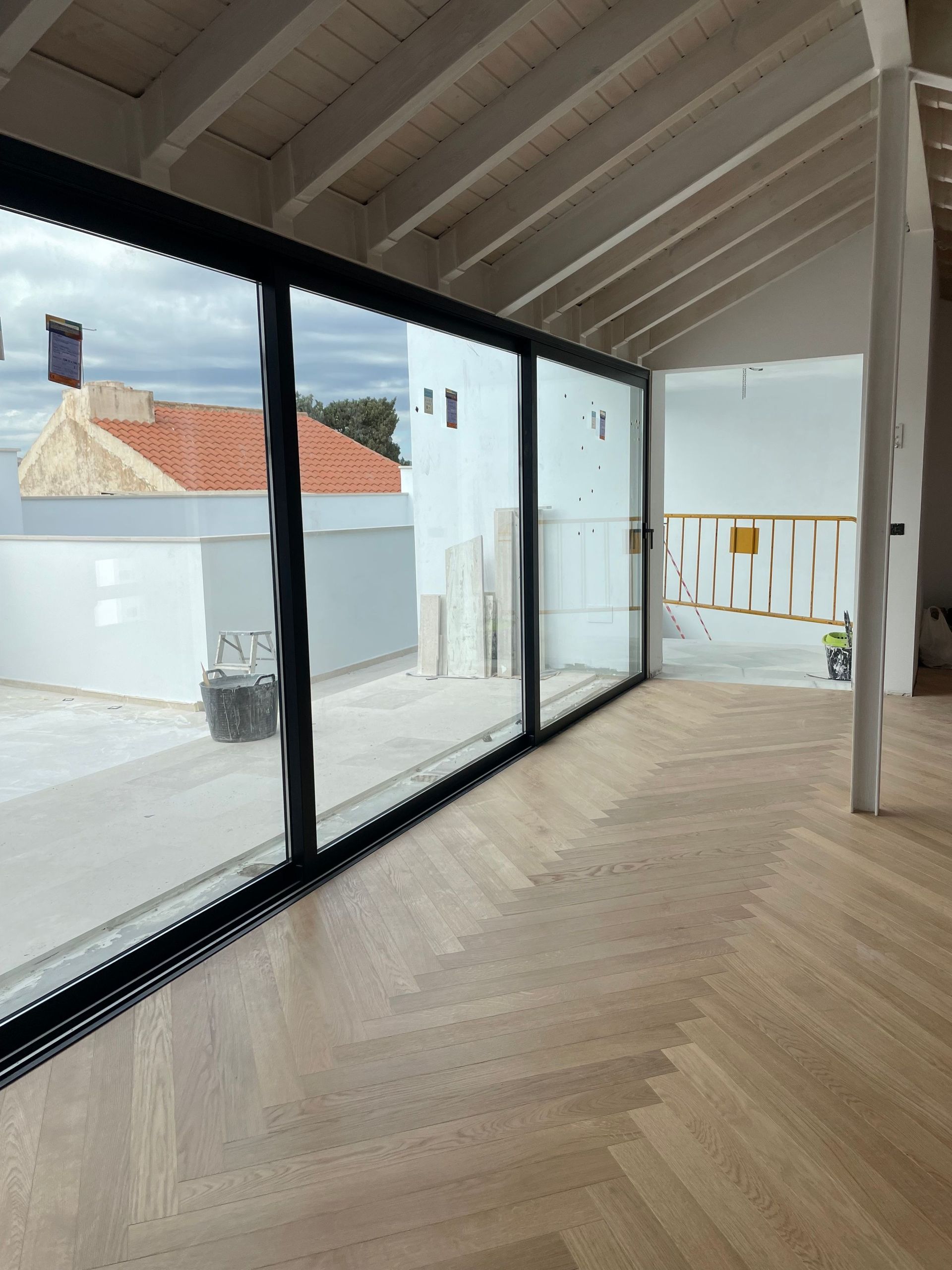 Una habitación grande con muchas ventanas y suelo de madera.