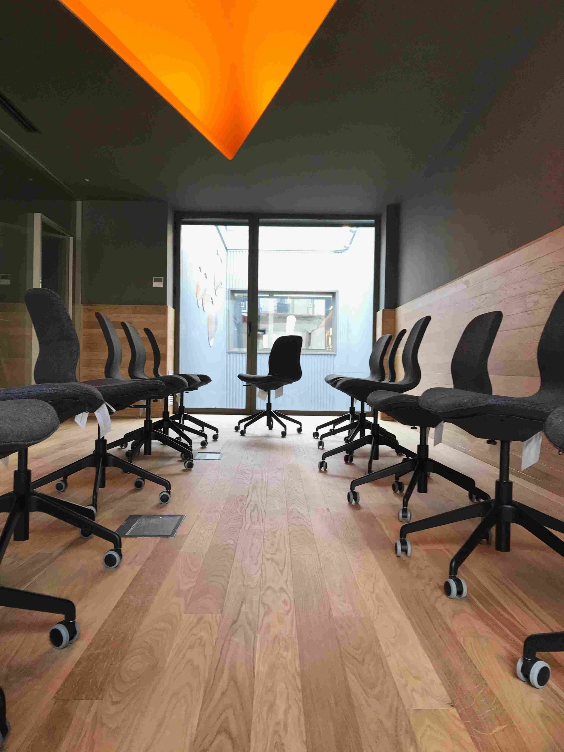 Una fila de sillas de oficina están alineadas en una habitación.