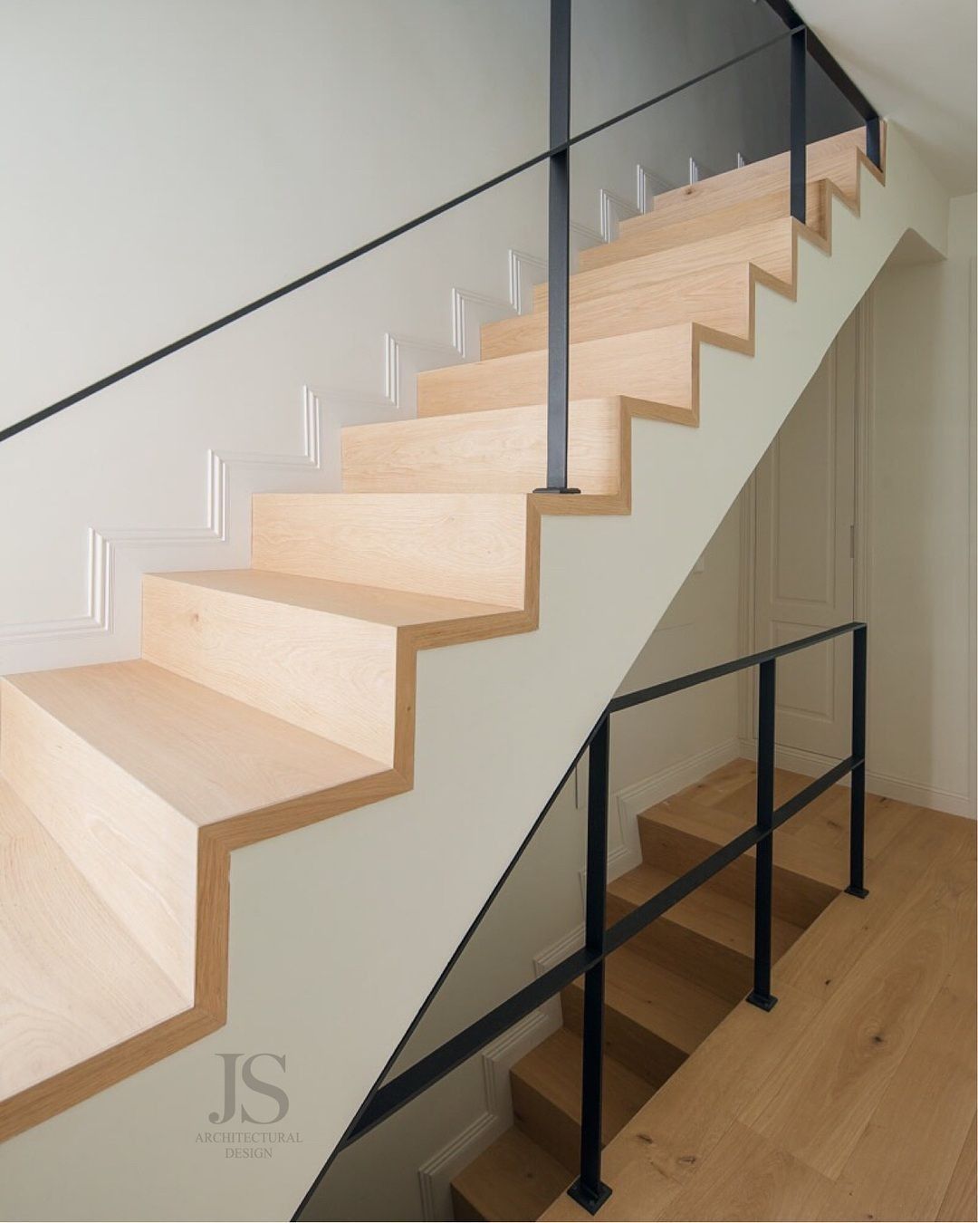 Una escalera de madera con una barandilla negra y la palabra js en la parte inferior.