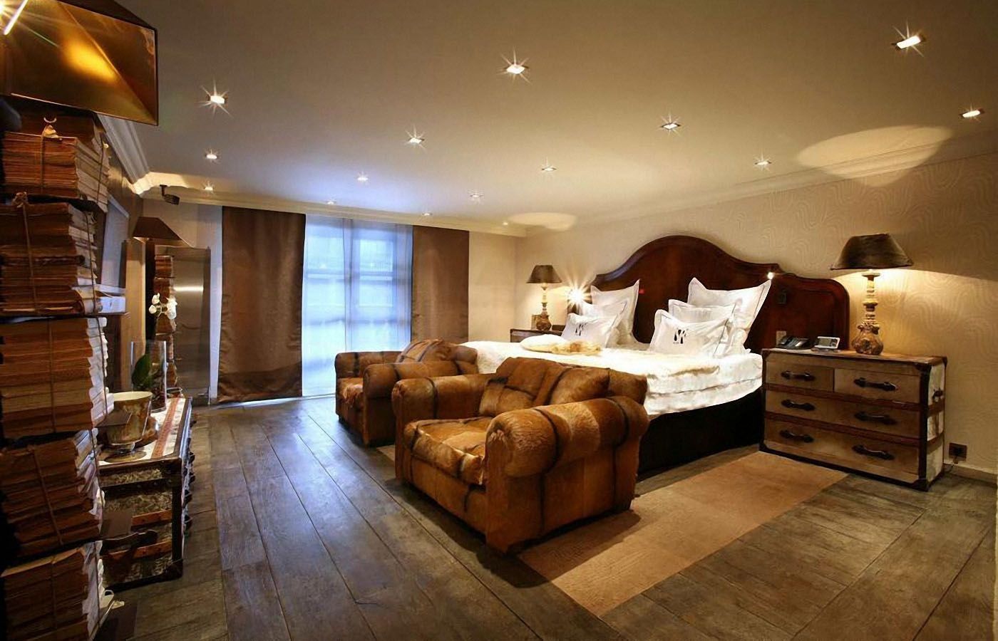 Un dormitorio grande con una cama grande y dos sillas.