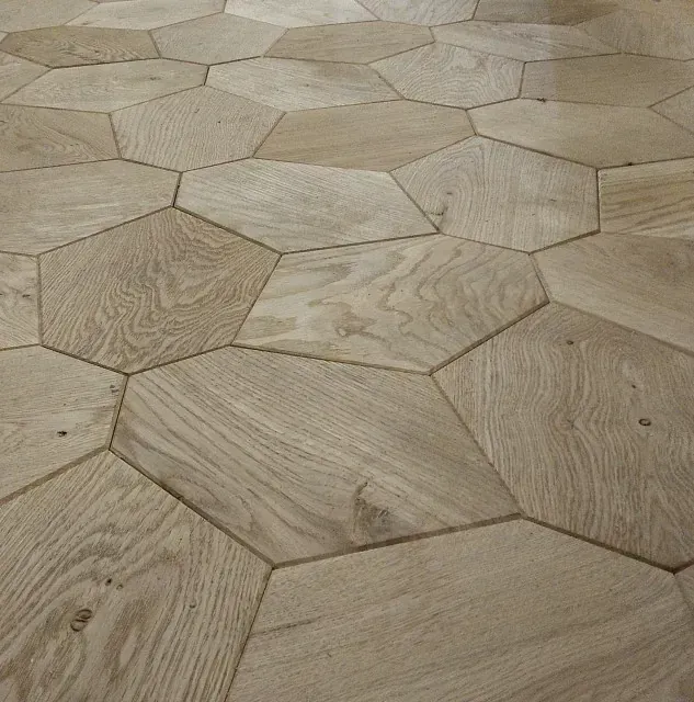 Un primer plano de un suelo de madera con baldosas hexagonales.
