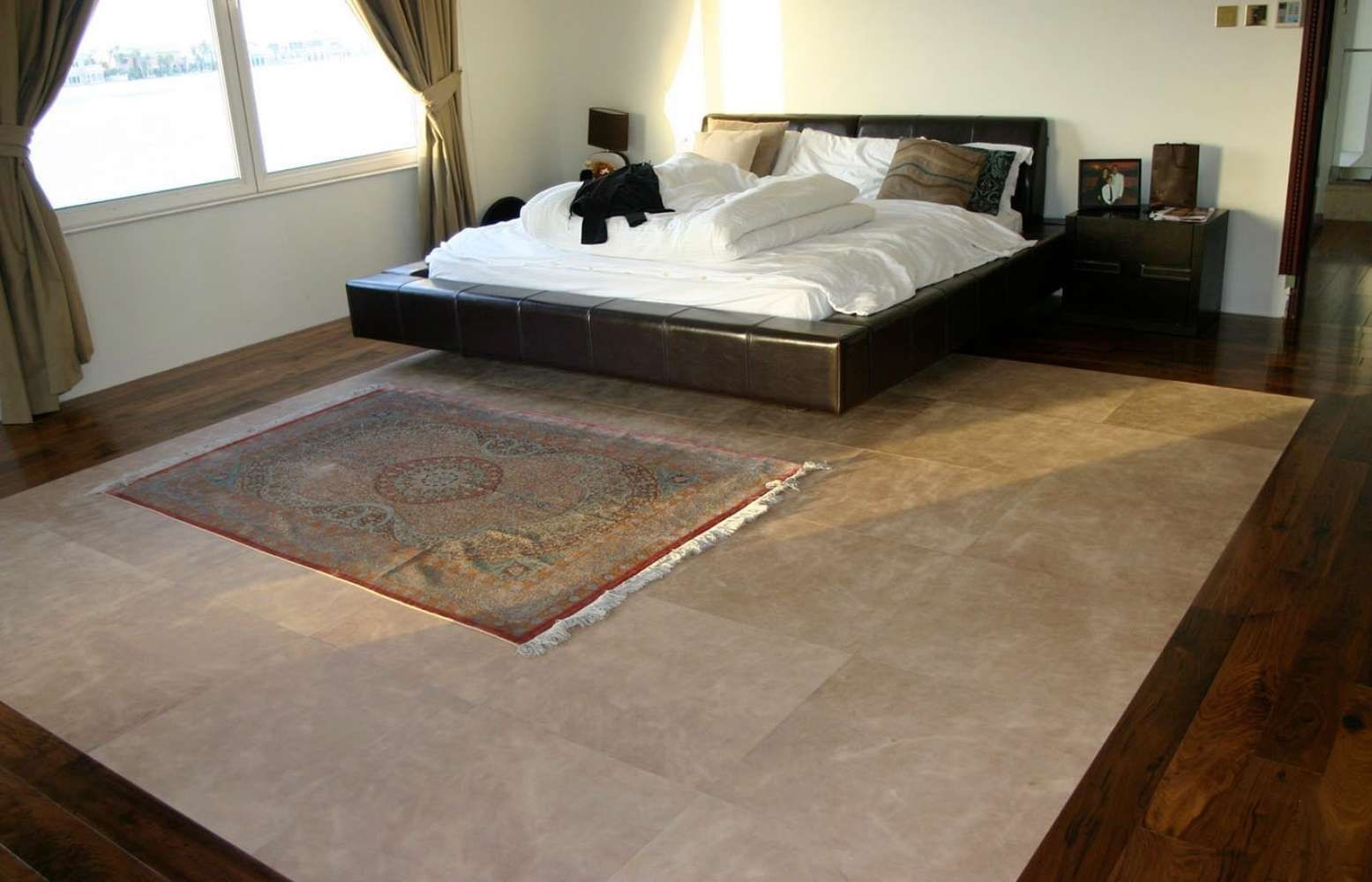 Un dormitorio con una cama y una alfombra en el suelo.