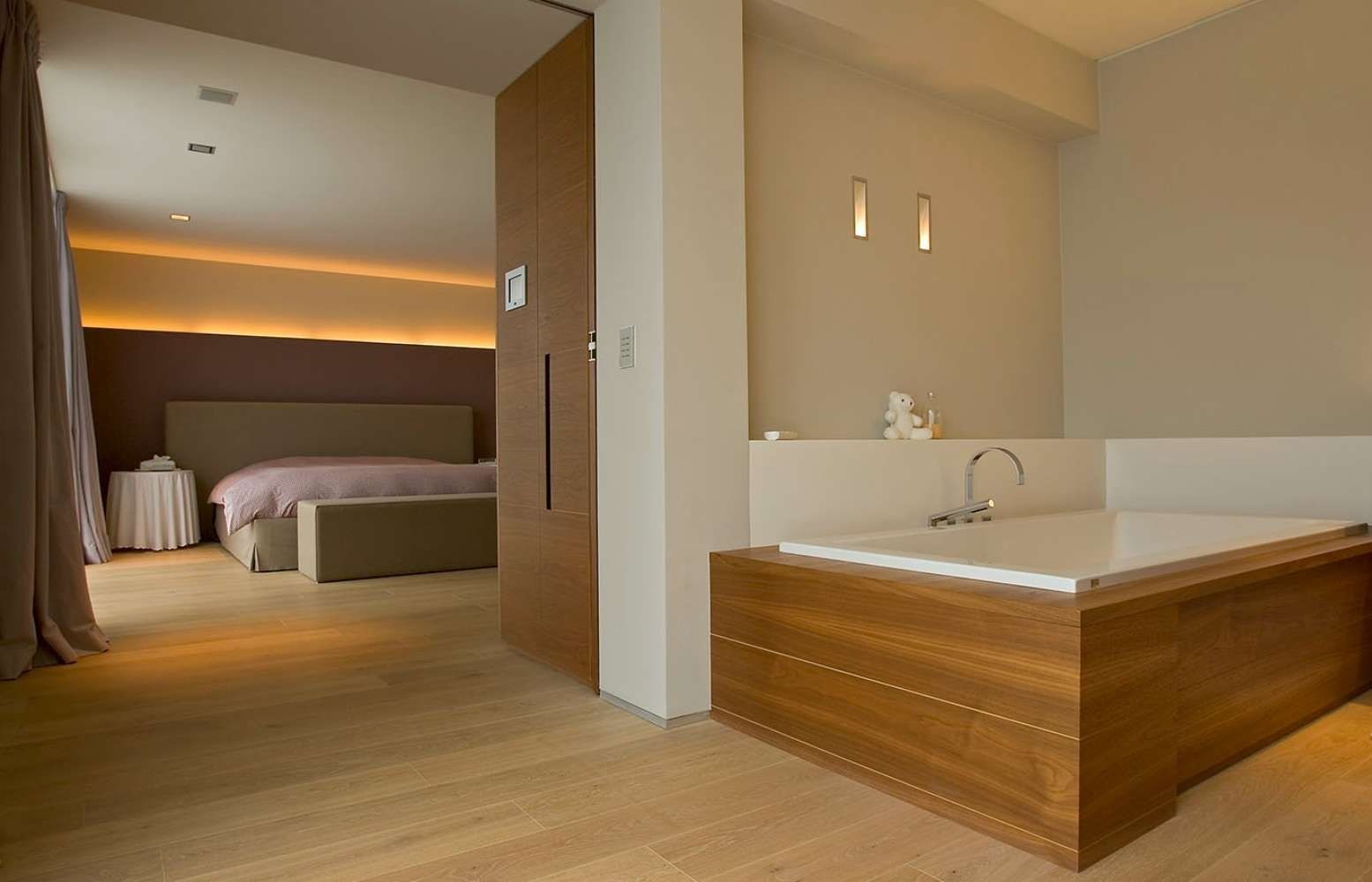 Un baño con bañera de hidromasaje al lado de un dormitorio.