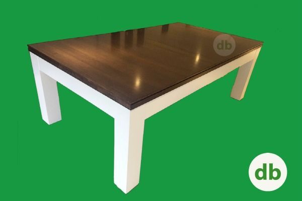 Mesa de centro rectangular con tapa de color marrón oscuro y patas blancas, sobre fondo verde.