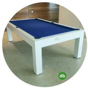 Mesa de billar blanca con fieltro azul, en una habitación con paredes y suelo de color claro. La mesa tiene el logotipo 