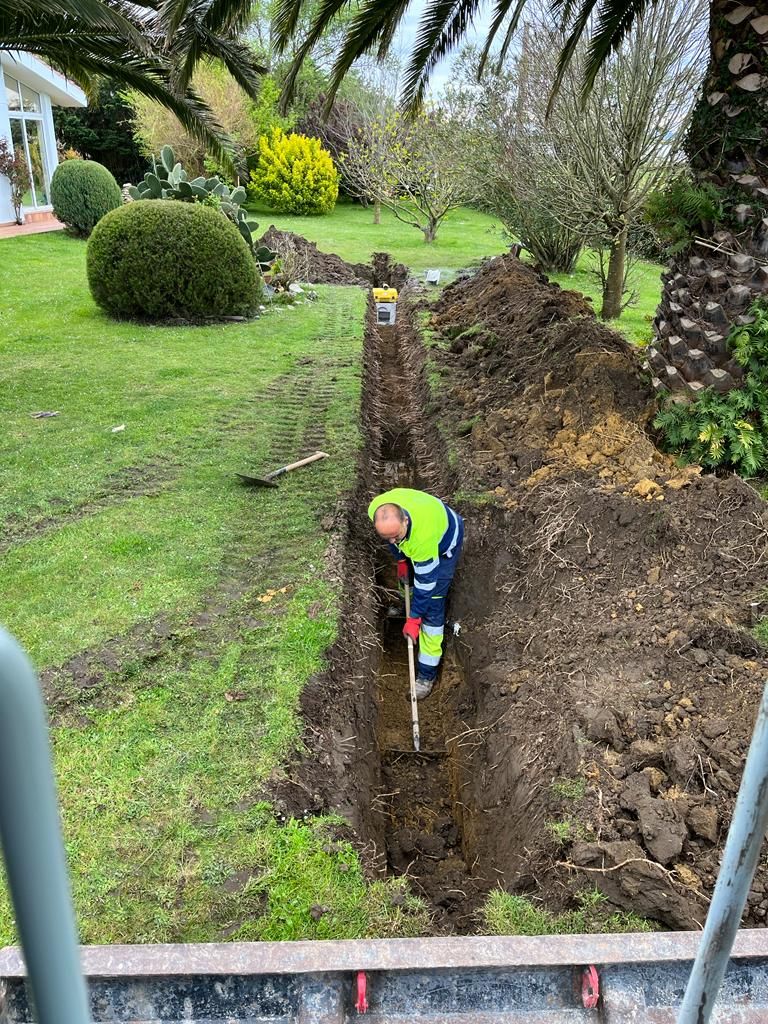 Un hombre está cavando un hoyo en el suelo de un jardín.